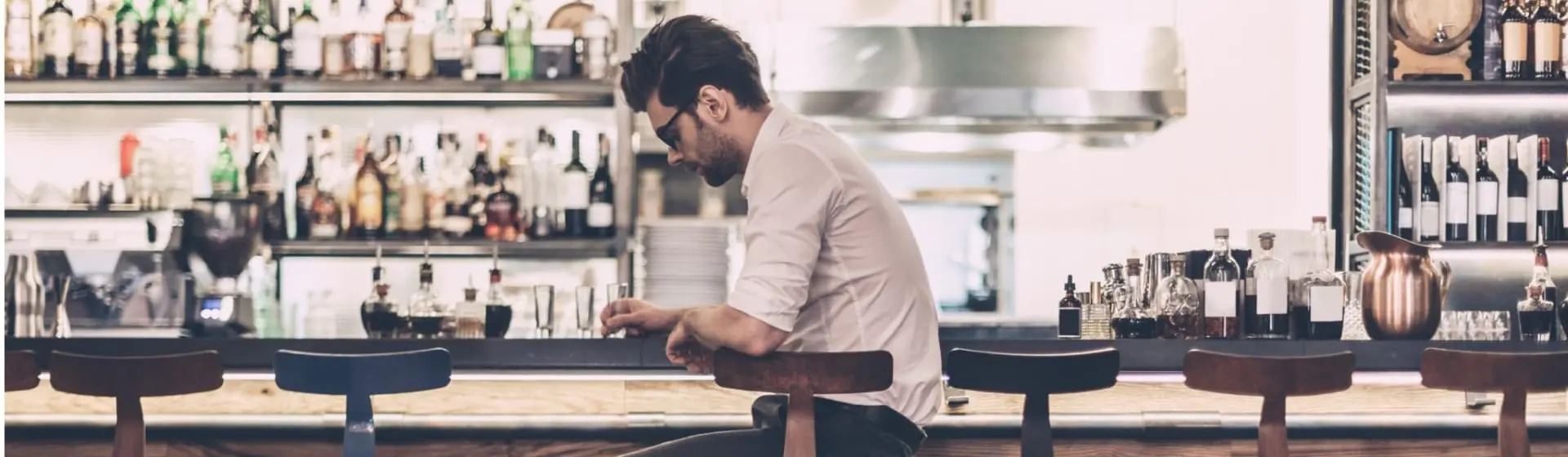 Man at bar staring down.
