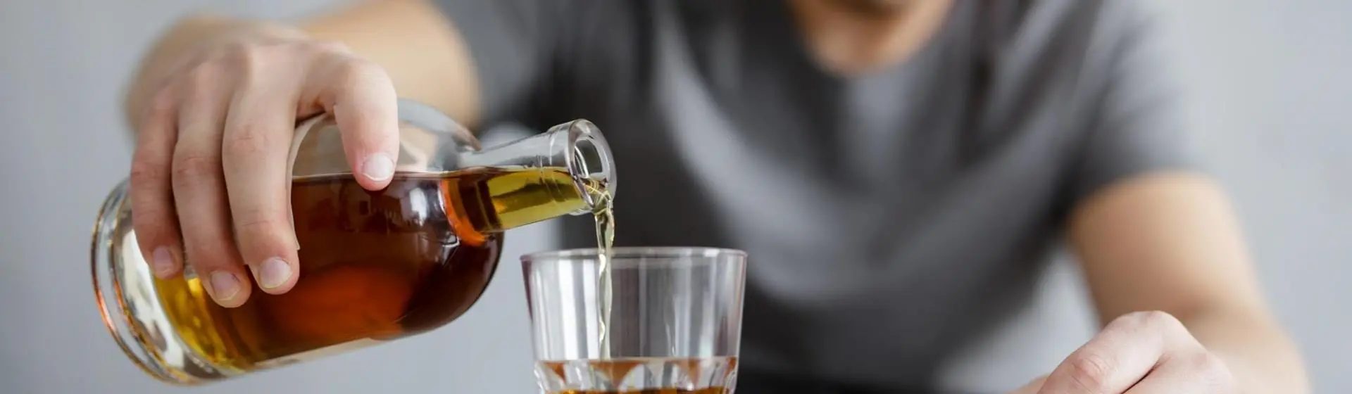person pouring alcohol into glass.